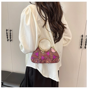Deep purple sequin evening bag with gold circular handle shown on model's shoulder