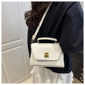 Close-up of white textured PU leather bag with golden twist-lock and slim shoulder strap