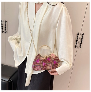 Detail of fuchsia sequin evening bag featuring floral embroidery and gold metal handle