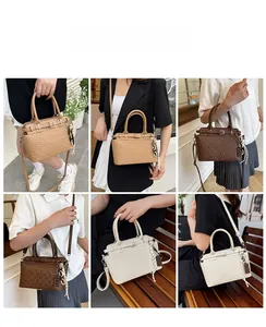 Detail view of vintage embossed tote bag in khaki and brown with chic chocolate charm