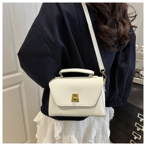 White lychee grain crossbody bag with gold twist lock shown from a side-view on a model