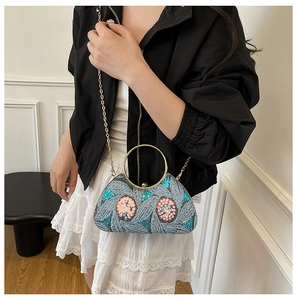 Close-up of sequin floral embroidery晚宴包 with a golden metal ring handle and chain strap