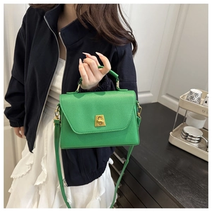 Detail of green litchi grain leather bag with a vintage gold metal twist lock buckle