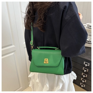 Green lychee pattern leather handbag with gold twist lock shown on model's shoulder