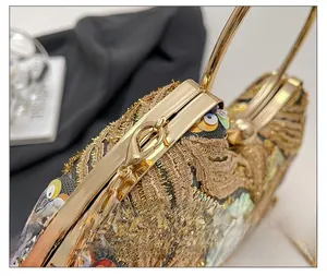 Macro detail of golden metal frame and intricate sequin embroidery on the evening clutch