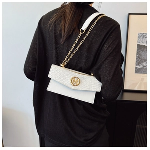 Detail of white woven leather crossbody bag featuring a gold M-shaped metal buckle