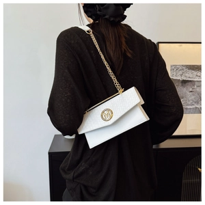 Close-up of white woven leather handbag featuring a golden 'M' metal logo and chain strap