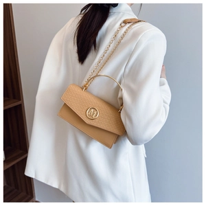 Detail of beige square bag showing woven texture, gold M logo, and chain strap with model