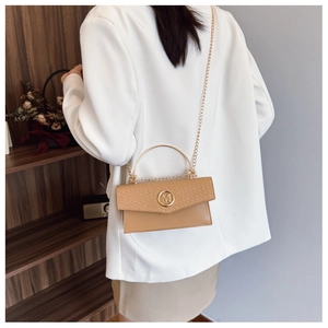 Detail of woven texture flap and golden M-letter buckle on khaki crossbody bag