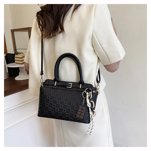 Lifestyle shot of black patterned tote bag worn on shoulder in a cozy cafe setting