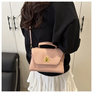 Detail of pink pebbled leather crossbody bag with gold twist-lock and top handle