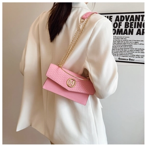 Close-up of pink envelope bag showing woven texture and gold M-logo buckle detail