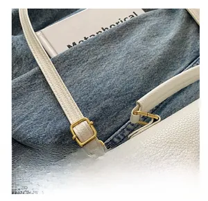 Detail of adjustable white lychee leather shoulder strap with golden metal buckle