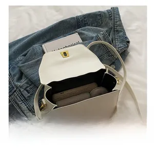 Top view of white textured leather bag showing interior capacity and gold twist lock