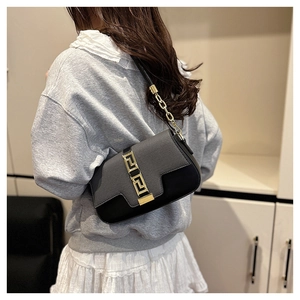 Detail of black saddle bag showing premium texture mix and gold geometric buckle