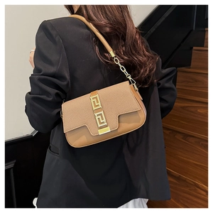 Detailed view of brown leather saddle bag with woven texture and gold geometric buckle