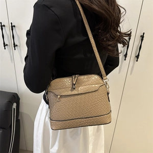 Large capacity woven shell crossbody bag in beige worn by a model in a modern interior
