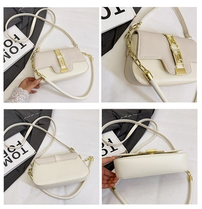 Detail view of cream saddle bag with Greek key gold clasp and mixed leather texture