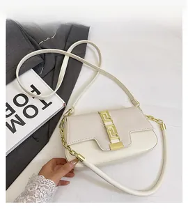 Detail view of cream saddle bag with golden square buckle and textured leather stitching