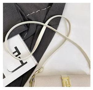 Detailed close-up of cream saddle bag with golden buckle and textured finish