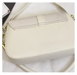 Detail of cream saddle bag with smooth leather and woven texture contrast