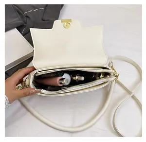 Macro view of white leather bag interior showing spacious compartments and golden chain