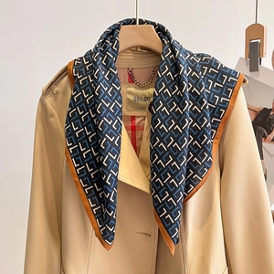 Foulard en soie bleu marine à motifs géométriques associé à un trench-coat classique kaki