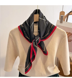 Détail d'un foulard en soie à motif géométrique noir et rouge avec haut en maille
