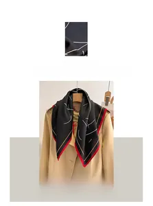 Détail rapproché d'un foulard noir en coton et lin avec bordures rayées tricolores