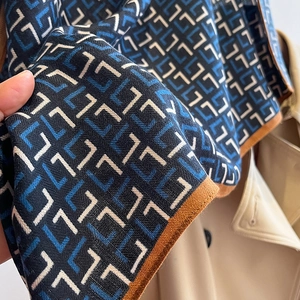 Détail du foulard en soie au motif géométrique en L avec bordures contrastées