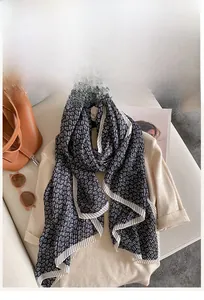Detail showing the pleated texture and floral pattern of a cotton linen scarf with white trim