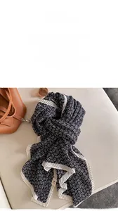 Detail of paisley print scarf with pleated white edges styled with fashion accessories