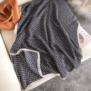 Navy and white cotton linen waffle texture scarf shawl draped over a leather sofa