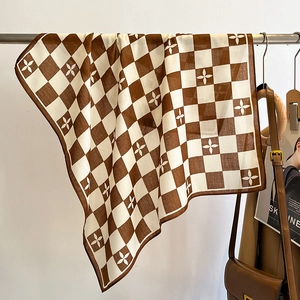 Gros plan de l'écharpe à damier avec motifs floraux et bords roulés soignés