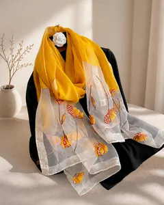 Detail of silk blend scarf featuring floral embroidery and elegant beaded embellishments