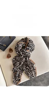 Detail shot of the micro-pleated leopard print scarf with soft beige and black patterns