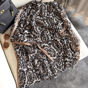 Detail of leopard print cotton linen scarf featuring micro-pleated texture and brown edge trim