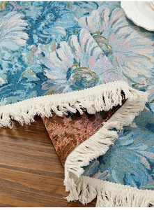 Detail of blue sunflower jacquard table runner with white cotton fringe on wood table