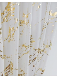 Detail of white velvet curtain fabric with metallic gold marble texture and foil accents