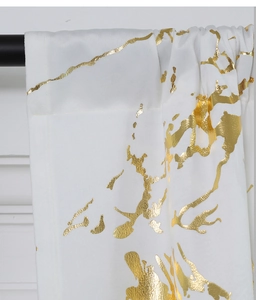 Detail of white velvet curtain with gold marble foil print on matte black curtain rod