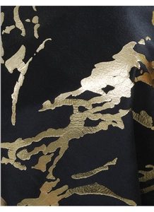 Detail of black Holland velvet fabric with luxurious gold foil marble texture patterns