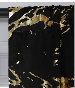 Detail of black velvet curtain featuring luxury gold marble foil print and soft texture