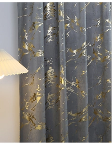 Detail of dark grey velvet curtain featuring luxurious gold marble texture and foil patterns