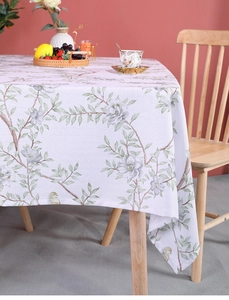 Close-up of botanical floral pattern on linen tablecloth placed on a wooden table