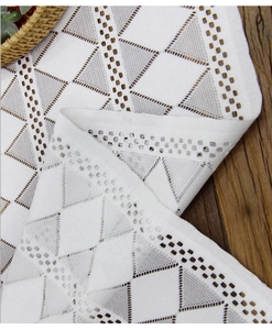 Detail of white lace table runner featuring geometric triangle hollow-out embroidery