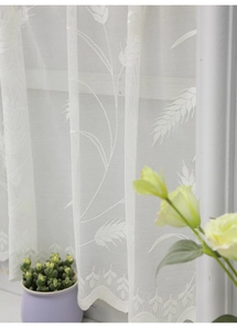 Dettaglio della tenda da cucina in pizzo bianco con jacquard di foglie e bordo smerlato