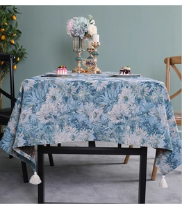 Detail of blue floral jacquard tablecloth with elegant white fringe tassels on edges