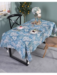 Blue impressionist floral table runner with white tassels shown in a cozy dining room