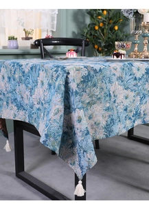 Detailed texture of blue floral jacquard table runner with white cotton tassel trim