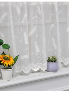 Close-up of white lace curtain with delicate wheat embroidery and scalloped edges